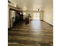 Spacious kitchen with stainless steel appliances, dark wood cabinets, and wood-look tile extending to backyard patio at 7135 W Heatherbrae Dr, Phoenix, AZ 85033