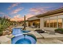 Expansive backyard boasting a gorgeous pool with spa, lush desert landscaping, covered patio, and outdoor dining at 7315 E Brisa Dr, Scottsdale, AZ 85266