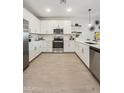 Modern kitchen with white cabinetry, stainless steel appliances, and a functional layout for cooking and entertaining at 7439 S 76Th Dr, Laveen, AZ 85339