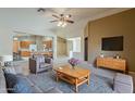 Cozy living room with neutral tones, ceiling fan, and an open layout to the kitchen at 8660 E Nido Ave, Mesa, AZ 85209