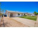 Single-story home featuring a covered parking area, well-maintained lawn, and tidy landscaping at 1058 E 2Nd St, Mesa, AZ 85203