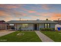 Charming single-story home boasts a manicured lawn and inviting brick pathway to the front door at 1058 E 2Nd St, Mesa, AZ 85203