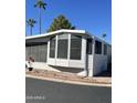 Charming mobile home with a screened-in porch, surrounded by desert landscaping and a quaint red rock border at 111 S Greenfield -- # 602, Mesa, AZ 85206