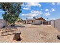Spacious backyard with gravel landscaping, mature trees, and a block wall fence at 1160 E Hampton Cir, Mesa, AZ 85204