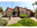Attractive exterior of home, featuring desert landscaping, a brick walkway, and mature shrubs at 18610 N 45Th Ave, Glendale, AZ 85308