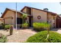 Attractive exterior of home, featuring desert landscaping, a brick walkway, and mature shrubs at 18610 N 45Th Ave, Glendale, AZ 85308