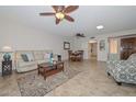 Bright living room with tile floors, ceiling fans, and comfortable seating, creating a welcoming atmosphere at 19120 N 98Th Ln, Peoria, AZ 85382