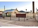 Backyard featuring a wrought-iron fence, mature trees, and an inviting exterior at 2014 N 17Th Pl, Phoenix, AZ 85006