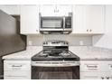 Close up of a stainless steel electric range with white cabinets and granite countertops at 2025 E Campbell Ave # 137, Phoenix, AZ 85016