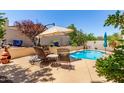 Relaxing poolside patio area with lounge chairs and umbrella for shade at 2129 E Beautiful Ln, Phoenix, AZ 85042