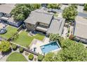 Aerial view of a backyard with a sparkling pool, lush lawn, patio area, and mature landscaping at 3062 E Cullumber St, Gilbert, AZ 85234