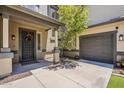 Charming front porch featuring a decorative door, covered entry, mature tree, and an attached two-car garage at 3062 E Cullumber St, Gilbert, AZ 85234