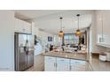 Modern kitchen with an island, pendant lighting, stainless steel appliances, and white cabinetry at 3341 S Lily Ave, Mesa, AZ 85212