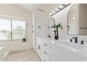 Bright bathroom featuring double sinks, quartz countertop, and modern fixtures at 4933 E Downing St, Mesa, AZ 85205