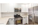 An efficient kitchen featuring stainless steel appliances, white cabinets, and light countertops at 5450 E Deer Valley Dr # 1211, Phoenix, AZ 85054