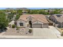 Aerial view showcasing the property's well-maintained exterior, including a three-car garage and desert landscaping at 8068 W Carlota Ln, Peoria, AZ 85383