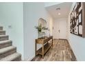 Welcoming entryway with stairs, console table, decorative mirror, and hardwood floors at 8323 E Peterson Ave, Mesa, AZ 85212