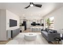 Bright living room with an open-concept kitchen and a modern gray sofa at 9645 W Kimberly Way, Peoria, AZ 85382