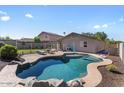 Backyard view showcasing a uniquely shaped private in-ground pool and patio at 1057 E Silversmith Trl, San Tan Valley, AZ 85143