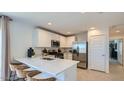 Modern kitchen featuring white cabinetry, stainless appliances, and a breakfast bar with seating at 12469 E Verbina Ln, Florence, AZ 85132