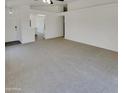 Bright living room with white walls, ceiling fan, and light carpet at 13030 W Hearn Rd, El Mirage, AZ 85335