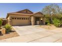 Lovely home showcasing a neat driveway, two car garage, and manicured landscaping at 17038 W Mohave St, Goodyear, AZ 85338