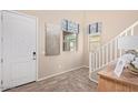Inviting entryway with tile floors, white door, staircase, and natural light from nearby windows at 17154 W Las Palmaritas Dr, Waddell, AZ 85355