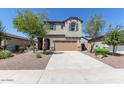 Charming two-story house with desert landscaping, a wide driveway, and a welcoming facade at 17154 W Las Palmaritas Dr, Waddell, AZ 85355
