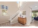 Bright foyer with tile flooring, staircase, and a view into another room through sliding glass doors at 17154 W Las Palmaritas Dr, Waddell, AZ 85355