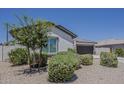 View of a cozy single-story home featuring a two-car garage and desert landscaping at 18766 N Salerno Dr, Maricopa, AZ 85138
