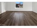 A living room with beautiful wood floors and a large window offering neighborhood views at 1901 E Hearn Rd, Phoenix, AZ 85022