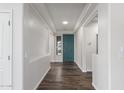 Bright foyer with wood-look floors, a teal door, and decorative wall trim at 19318 E Reins Rd, Queen Creek, AZ 85142