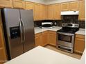 Modern kitchen with stainless steel appliances, light wood cabinets, and light countertops at 1970 W Park Pl, Chandler, AZ 85224