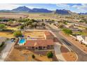 Aerial view of property with a pool, mountain views, desert landscaping, and proximity to town at 20911 E Excelsior Ave, Queen Creek, AZ 85142