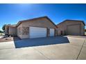 Spacious three-car garage with white doors and a concrete driveway offers ample parking and storage space at 20911 E Excelsior Ave, Queen Creek, AZ 85142
