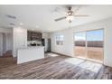 Bright open-concept living area with wood-look flooring and a sliding glass door to the backyard at 22012 E Wayward Ln, Red Rock, AZ 85145