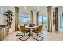 Bright dining room featuring elegant light fixture, large window, and sliding glass door at 23098 E Nightingale Rd, Queen Creek, AZ 85142