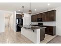 Well-equipped kitchen boasts a granite island, dark cabinetry, and stainless steel appliances at 2410 S 124Th Dr, Avondale, AZ 85323