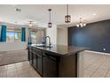 Open concept kitchen features an island with granite countertops and modern pendant lighting at 2410 S 124Th Dr, Avondale, AZ 85323