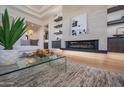 A well-lit living room shows a modern fireplace with a glass coffee table and a decorative plant at 3153 E Sierra Vista Dr, Phoenix, AZ 85016