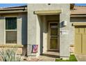 Exterior front porch with covered entry, desert landscaping, and American flag at 41793 W Canasta Ln, Maricopa, AZ 85138
