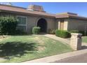 Charming single-story home featuring a brick facade, well-manicured lawn, and mature landscaping at 1036 E Wagon Wheel Dr, Phoenix, AZ 85020