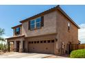 Side view of a tan two-story home with a two-car garage and a desert landscaped yard at 10830 W El Cortez Pl, Peoria, AZ 85383