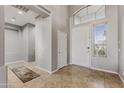 Bright entryway with tile flooring, high ceilings, and decorative transom window at 10897 S Turtle Dove S Dr, Goodyear, AZ 85338