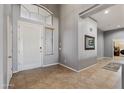 Welcoming foyer featuring tile floors, high ceilings, and a view of the laundry room at 10897 S Turtle Dove S Dr, Goodyear, AZ 85338