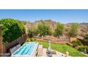 A landscaped backyard with a hot tub, turf, desert landscaping and views of a hill at 11025 N 10Th St, Phoenix, AZ 85020