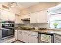 Bright kitchen features white cabinets, granite countertops, stainless steel appliances, and a garden view at 11025 N 10Th St, Phoenix, AZ 85020