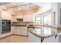 Bright kitchen features white cabinets, granite countertops, stainless steel appliances, and a breakfast bar at 11025 N 10Th St, Phoenix, AZ 85020