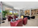 Comfortable and bright living space showcasing red chairs, fireplace, and views of the outdoor scenery at 11081 E Betony Dr, Scottsdale, AZ 85255