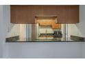 An open kitchen features granite counters and wood cabinetry at 1402 E Guadalupe Rd # 122, Tempe, AZ 85283